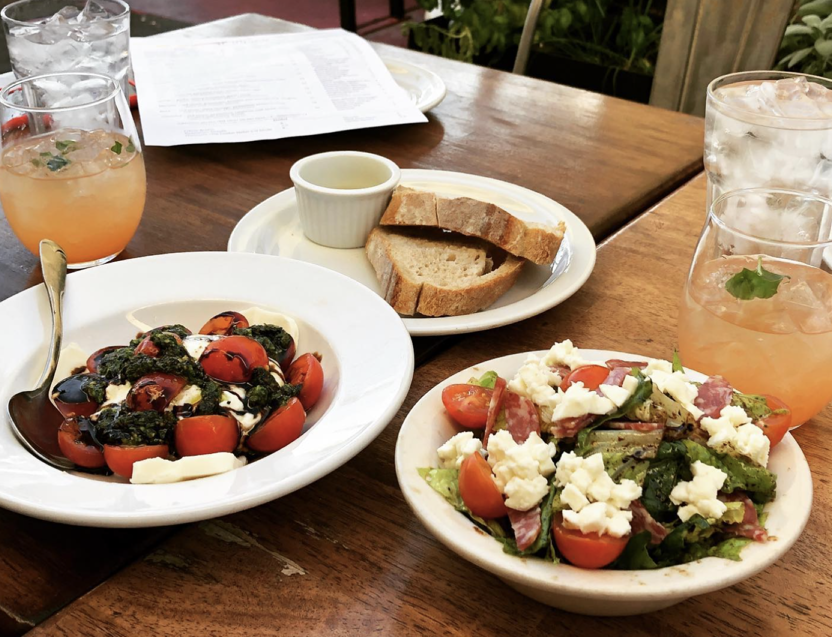IL Bosco salads and drinks arranged on a patio table
