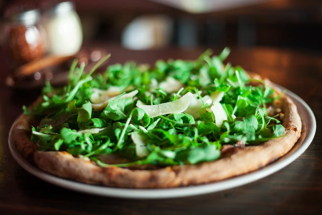 Pizza emerging from IL Bosco's wood-fired oven
