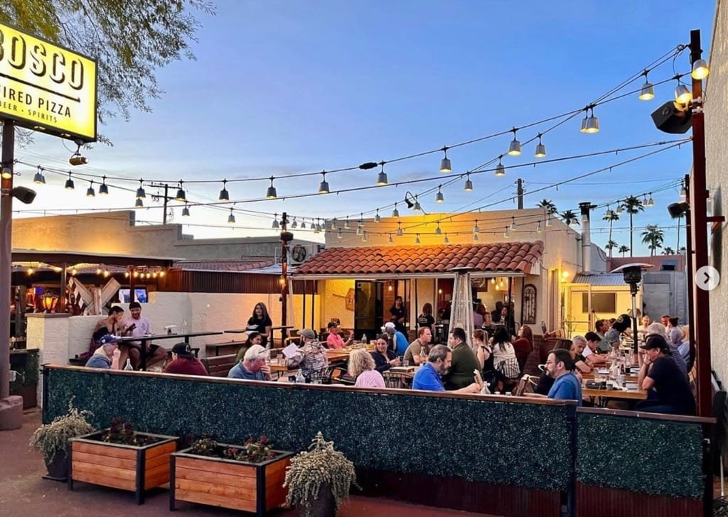 Guests dining on the Becker Lane patio at dusk