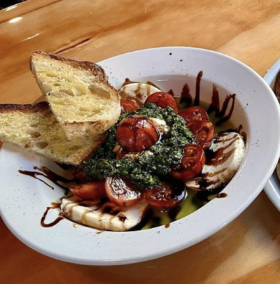 Caprese salad with tomatoes, fresh mozzarella, pesto, and balsamic