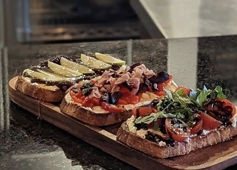 Bruschetta trio topped with fruit, prosciutto, and tomatoes